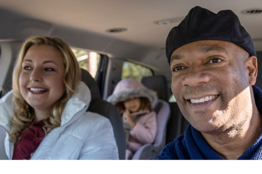 Actor portrayal of a happy family in a car