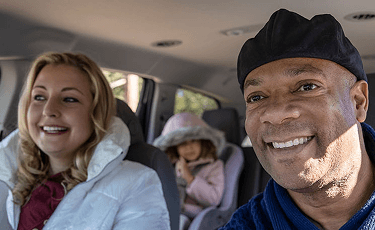 Actor portrayal of a happy family in a car